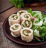 Gedämpfte Hühnerbrötchen mit Gemüse und Salat aus frischem Gemüse auf einer braunen Platte foto