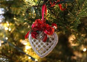 weiße filigrane Herzweihnachtsverzierung mit roter Schleife foto