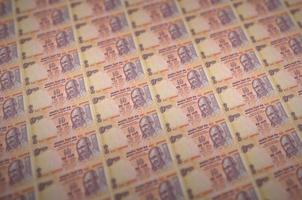 10 indische Rupienscheine, die in illegalem Geldproduktionsförderer gedruckt wurden. Collage aus vielen gefälschten Rechnungen. Konzept der Fälscherarbeit foto