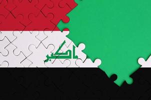 Die Irak-Flagge ist auf einem fertigen Puzzle mit freiem Platz für grüne Kopien auf der rechten Seite abgebildet foto