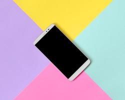 modernes smartphone mit schwarzem bildschirm auf texturhintergrund von modepastellblauem, gelbem, violettem und rosafarbenem papier in minimalem konzept foto