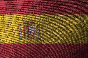 Spanien-Flagge wird auf dem Bildschirm mit dem Programmcode dargestellt. das konzept der modernen technologie und standortentwicklung foto