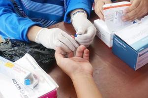 ost-kutai, ost-kalimantan, indonesien, 2022 - ein gesundheitspersonal führt einen fingerstichtest auf hiv durch, selektiver fokus foto