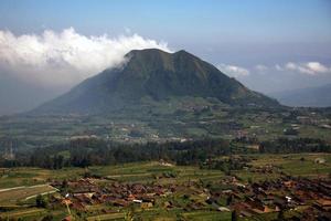 Blick auf das Dorf und die Felder auf einem wunderschönen Berghintergrund. Zentral-Java, Indonesien. foto