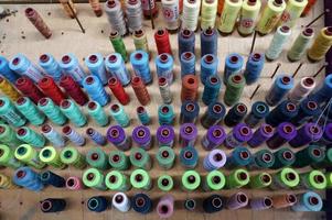 Bunte Fadenspulen, die in der Stoff- und Textilindustrie verwendet werden, mit selektivem Fokus foto