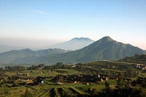 Blick auf das Dorf und die Felder auf einem wunderschönen Berghintergrund. Zentral-Java, Indonesien. foto