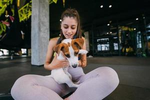 Süßer Jack-Russell-Hund im Fitnessstudio mit ihrer Besitzerin. foto