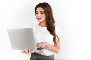 Frau gekleidet im Geschäftsstil arbeitet auf Laptop auf weißem Hintergrund