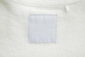 leeres weißes etikett für wäschepflegekleidung auf stoffstrukturhintergrund foto