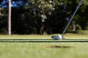 Nahaufnahme von Golfschläger und Ball im Gras. foto