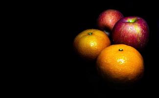 wassertropfen auf glänzender oberfläche von frischem orange und rotem apfel foto