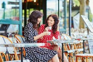 schöne Zwillingsschwestern trinken Kaffee in Paris foto