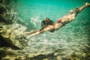 Frau, die sich in der Unterwasserwelt aufhält foto