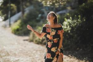 Frau im Blumenkleid, die sich am Sommertag amüsiert foto