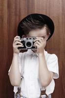 Junge, der mit alter Kamera fotografiert foto