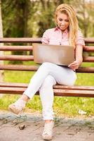 junge Frau mit Laptop im Park foto