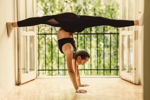 junge Frau, die beim Yoga Split-Übungen durchführt foto