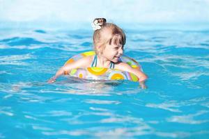 glückliches kleines Mädchen im Pool foto