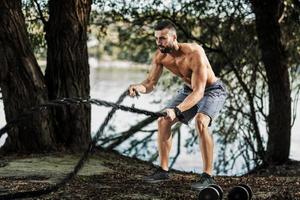 Mann Outdoor-Übung mit Seilen foto