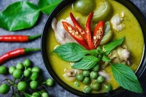 thailändisches essen grünes curry auf suppenschüssel mit zutat kräutergemüse auf dunklem plattenhintergrund - grünes curry hähnchenküche asiatisches essen auf dem tisch foto