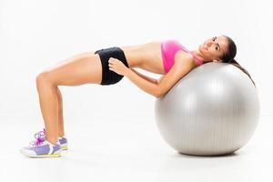 Trainieren und Heben der Gewichte mit Gymnastikball foto