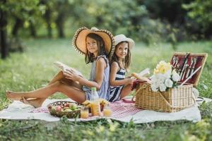 Zwei Schwestern haben Spaß im Park und genießen einen Picknicktag foto