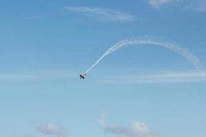 flugzeug machen rauchfahnen und schleifen. klarer blauer Himmel und Flugzeug foto