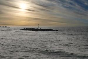 Steinbuhnen, Wellenbrecher im Wasser vor der Küste in Dänemark. Am Abend foto