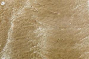 Hintergrund, Sand am Strand nach dem Abgang der Welle foto