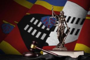 Swasiland-Flagge mit Statue der Justitia, Verfassung und Richterhammer auf schwarzem Vorhang. Begriff von Urteil und Schuld foto