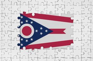 Ohio US-Staatsflagge im Rahmen aus weißen Puzzleteilen mit fehlendem Mittelteil foto