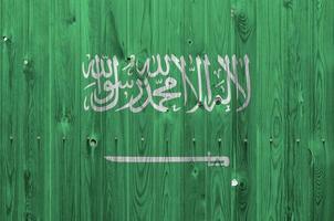 saudi-arabien-flagge in hellen farben auf alter holzwand dargestellt. strukturierte Fahne auf rauem Hintergrund foto