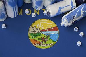 Montana US-Staatsflagge und einige gebrauchte Aerosol-Sprühdosen für Graffiti-Malerei. Street-Art-Kulturkonzept foto