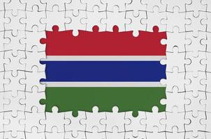Gambia-Flagge im Rahmen aus weißen Puzzleteilen mit fehlendem Mittelteil foto