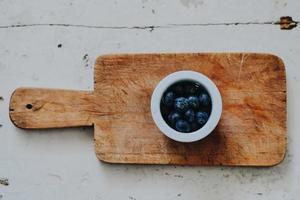 Schüssel Blaubeeren auf Schneidebrett foto