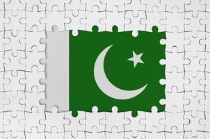 Pakistanische Flagge im Rahmen aus weißen Puzzleteilen mit fehlendem Mittelteil foto