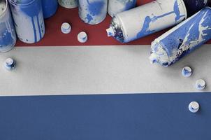 niederländische Flagge und einige gebrauchte Aerosol-Sprühdosen für Graffiti-Malerei. Street-Art-Kulturkonzept foto