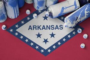 Arkansas US-Staatsflagge und wenige gebrauchte Aerosol-Sprühdosen für Graffiti-Malerei. Street-Art-Kulturkonzept foto