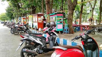 Probolinggo, Indonesien. 13. Juli 2022 – Motorräder und Kaufmannskarren reihen sich auf dem Stadtplatz aneinander foto