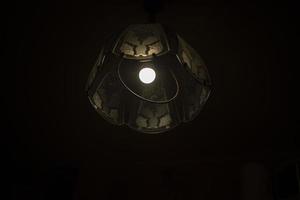 Lampe im Dunkeln. Kronleuchter mit einer Lampe. Lichtquelle. foto