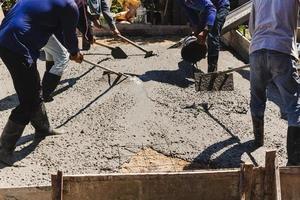 Arbeiter setzen und nivellieren den Beton im Fundament. foto