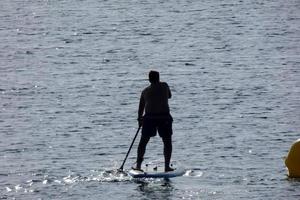 schwimmer im urlaub paddelsurfen im mittelmeer foto