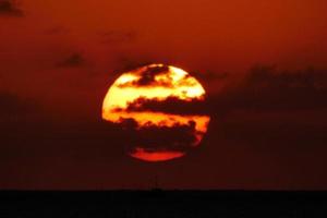 Sonnenscheibe, die über dem Horizont des Meeres aufgeht, Sonnenaufgang, Morgendämmerung foto