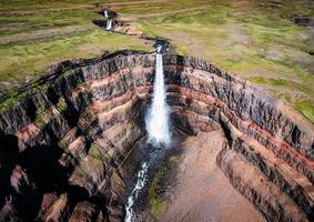 Hengifoss-Wasserfall, umgeben von Basaltschichten mit Wasser, das im Sommer auf Island fließt foto