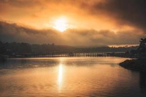 Sonnenaufgang über der Mon-Holzbrücke am Songkalia-Fluss und dem Mon-Dorf in Sangkhlaburi foto