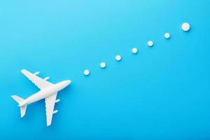 weißes Modell eines Passagierflugzeugs mit gepunkteten Flugbahnpunkten isoliert auf dem Hintergrund. die Route des Flugzeugs in den Ländern und im Himmel. foto