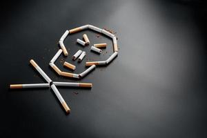 Schädel von Zigaretten auf schwarzem Hintergrund. das Konzept des Rauchens tötet. zum Konzept des Rauchens als tödliche Angewohnheit, Nikotingifte, Krebs durch Rauchen, Krankheit, Raucherentwöhnung. foto