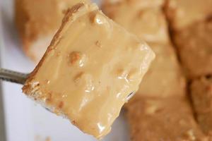 Draufsicht auf Erdnussbutter und ein Brot auf Teller auf schwarzem Hintergrund foto