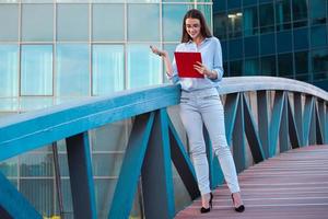 Executive Business Woman mit Zwischenablage vor dem städtischen Hintergrund foto