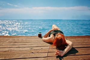 Rothaarige Frau genießt einen Urlaub am Meer. foto